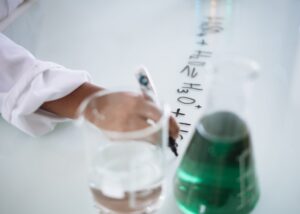 crop chemist taking science notes on whiteboard during experiment with liquids